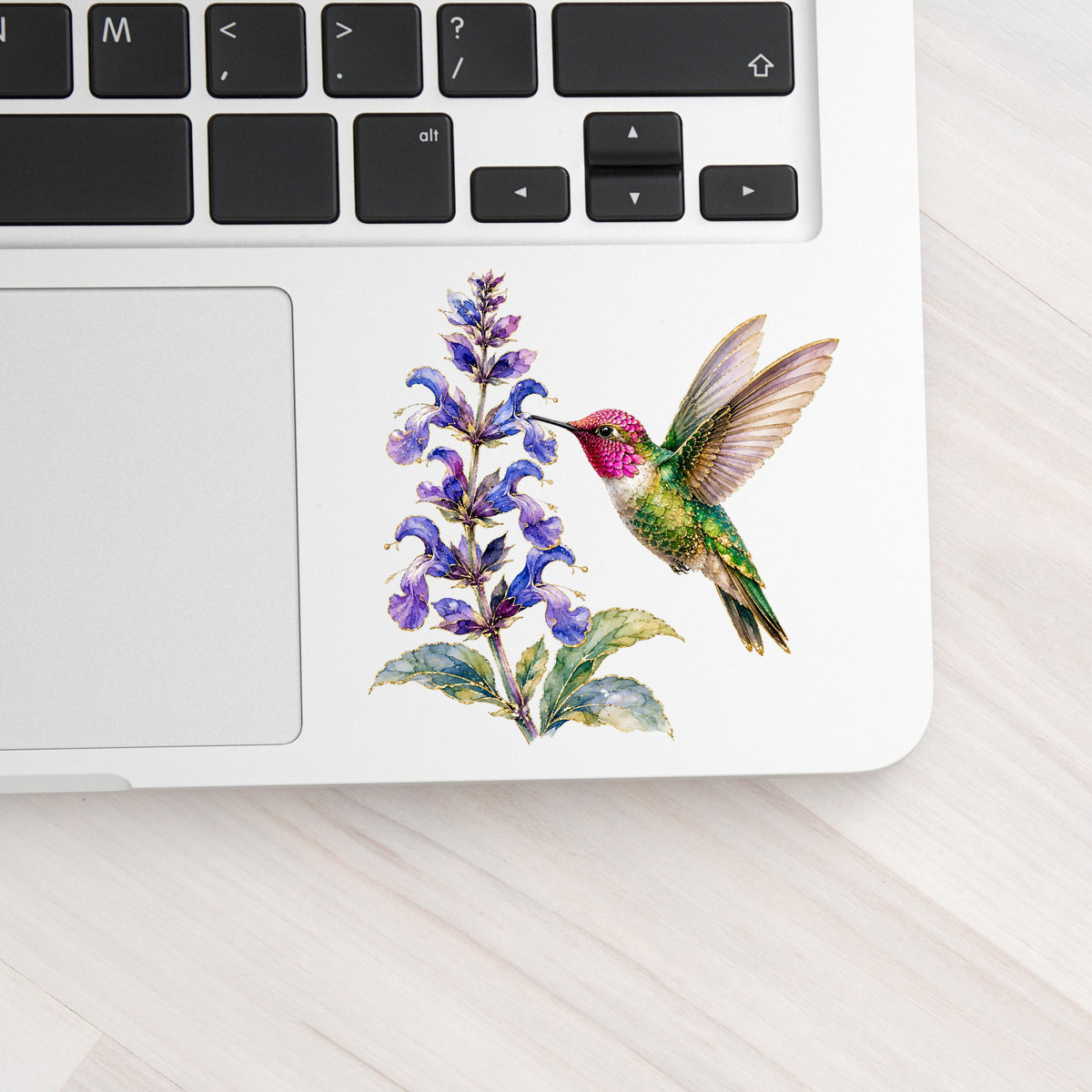 Hummingbird Purple Salvia UV DTF sticker applied to a silver laptop beside the keyboard
