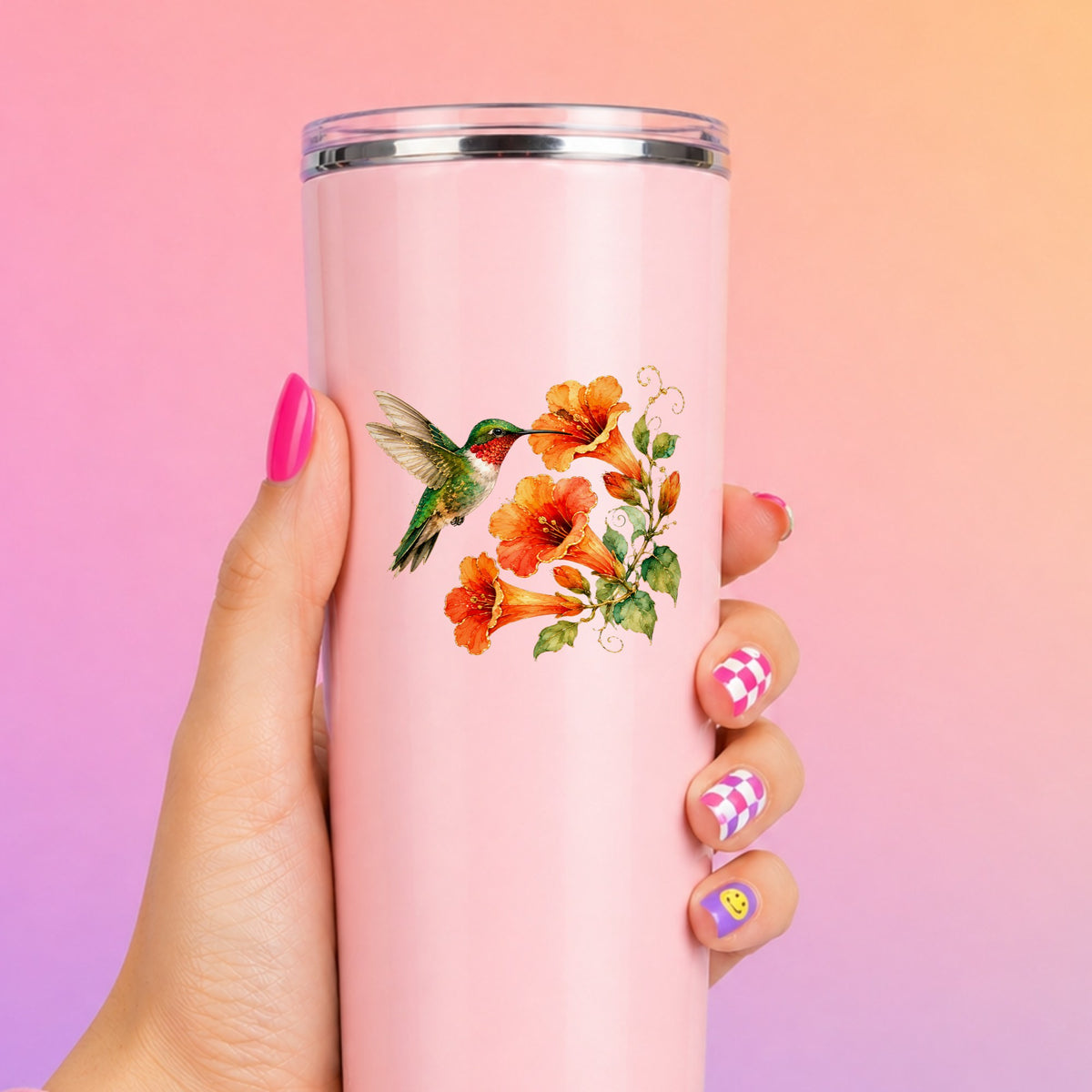 Red Throat Hummingbird Trumpet Flowers UV DTF sticker applied to a tall pink tumbler on a pink and orange background