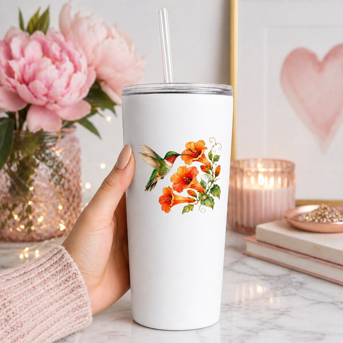 Red Throat Hummingbird Trumpet Flowers UV DTF sticker applied to a white straw tumbler beside pink peonies