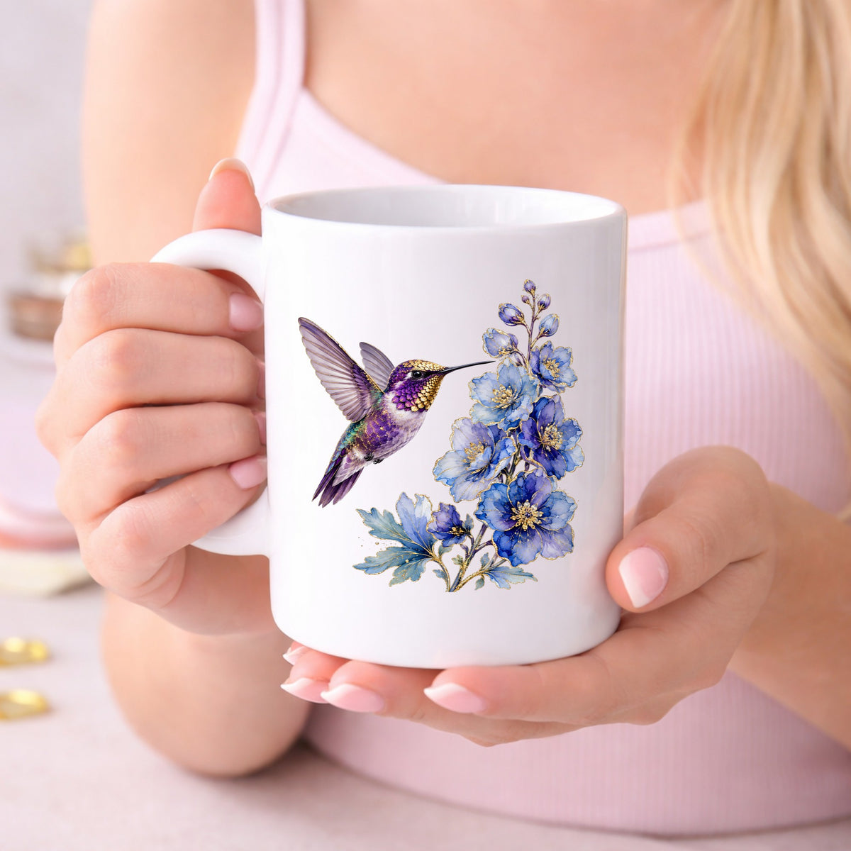 Purple Hummingbird Blue Delphinium UV DTF sticker applied to a white coffee mug held in both hands