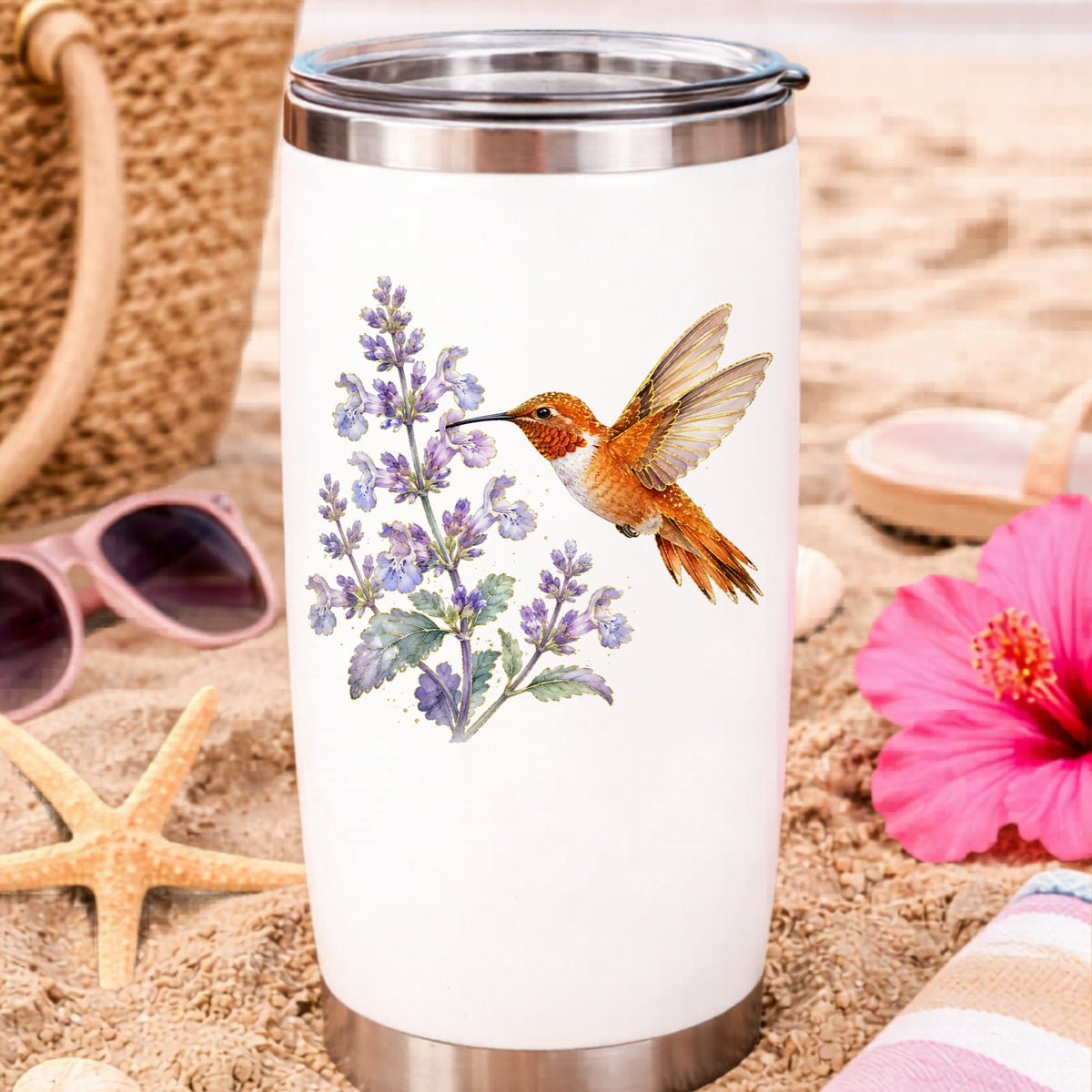 Rufous Hummingbird Lavender UV DTF sticker applied to a white travel tumbler on beach sand