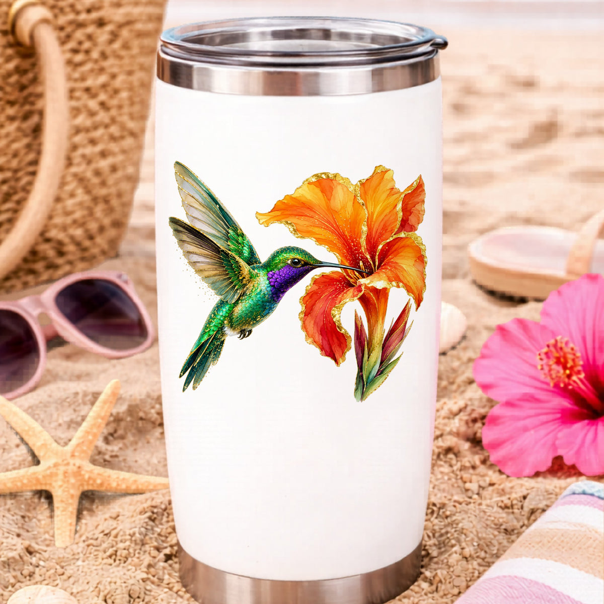 Hummingbird Orange Canna Lily UV DTF sticker applied to a white travel tumbler on beach sand