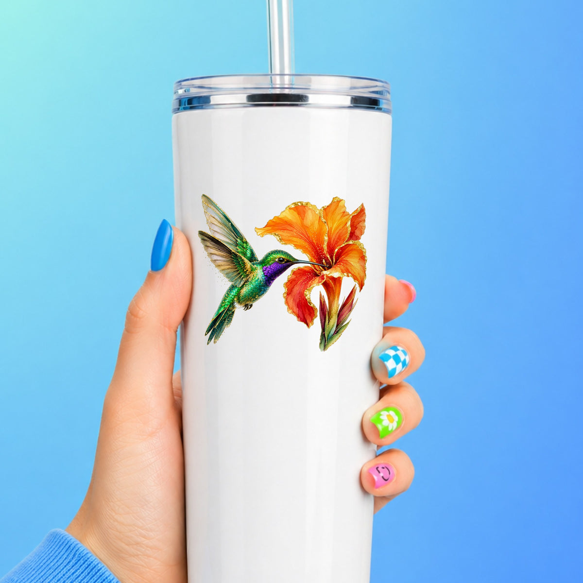 Hummingbird Orange Canna Lily UV DTF sticker applied to a white straw tumbler on a blue background