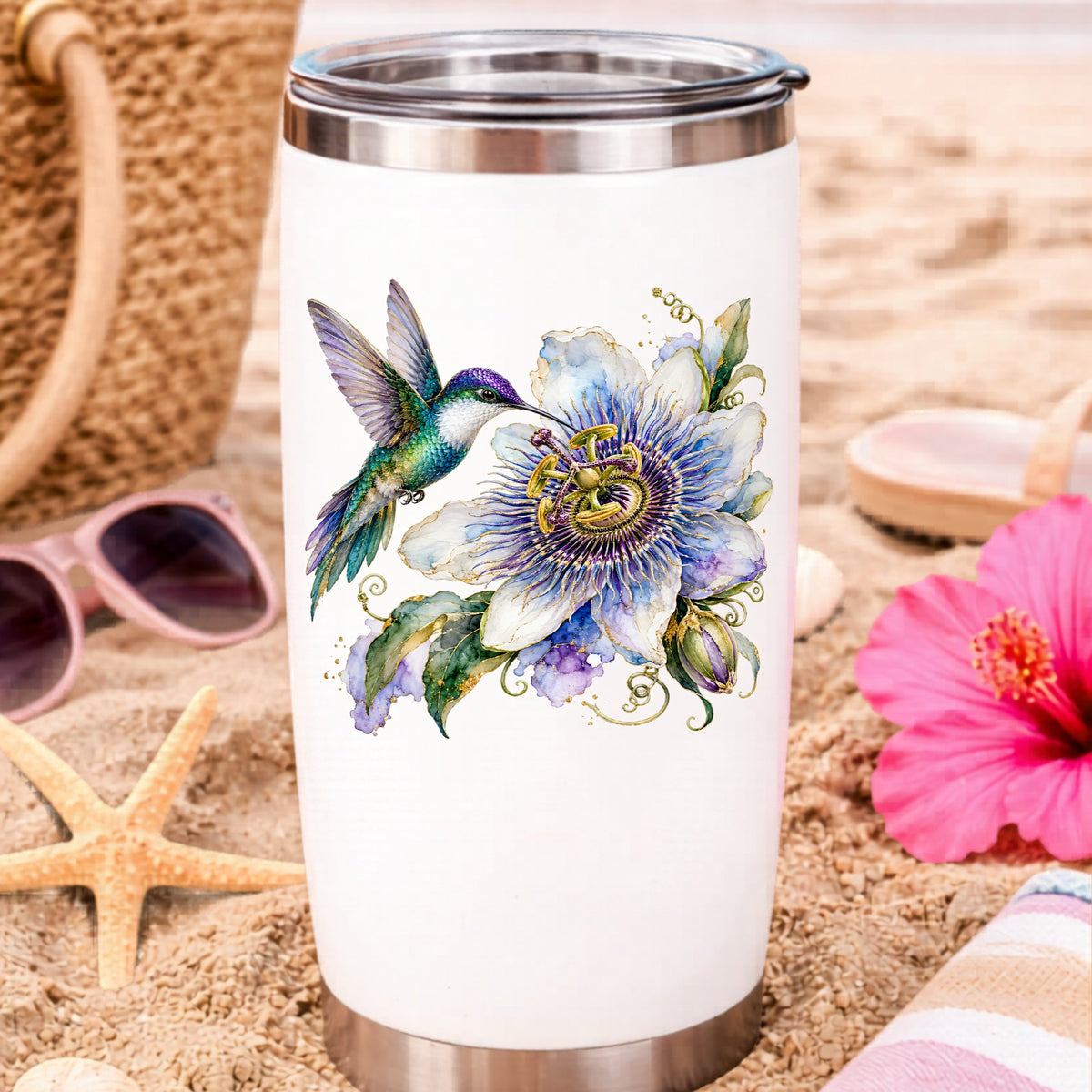 Hummingbird Passion Flower UV DTF sticker applied to a white travel tumbler on beach sand