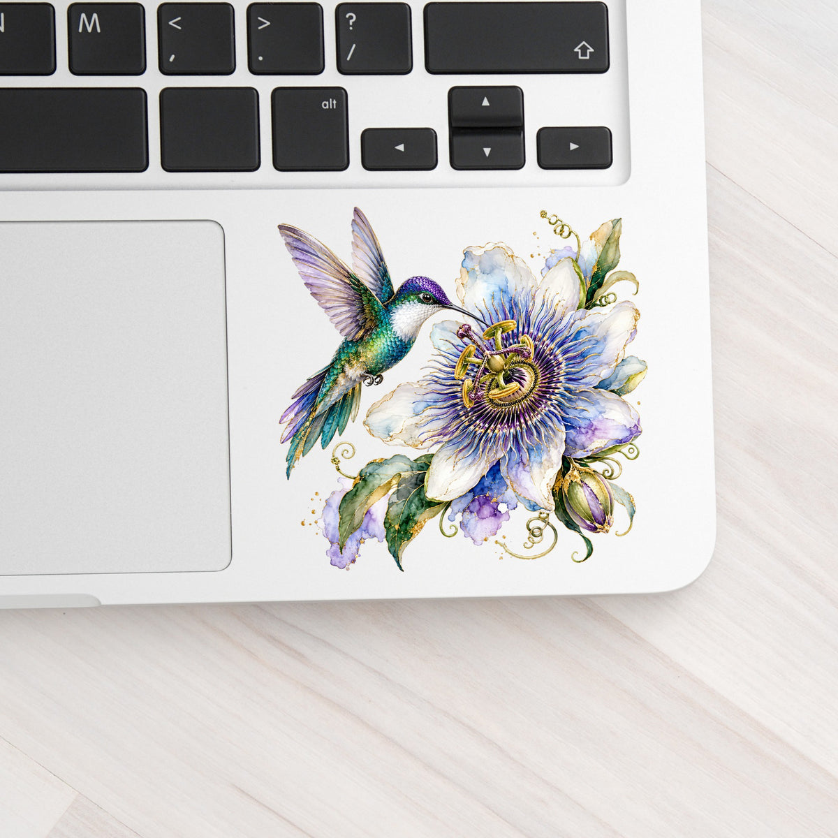 Hummingbird Passion Flower UV DTF sticker applied to a silver laptop beside the keyboard