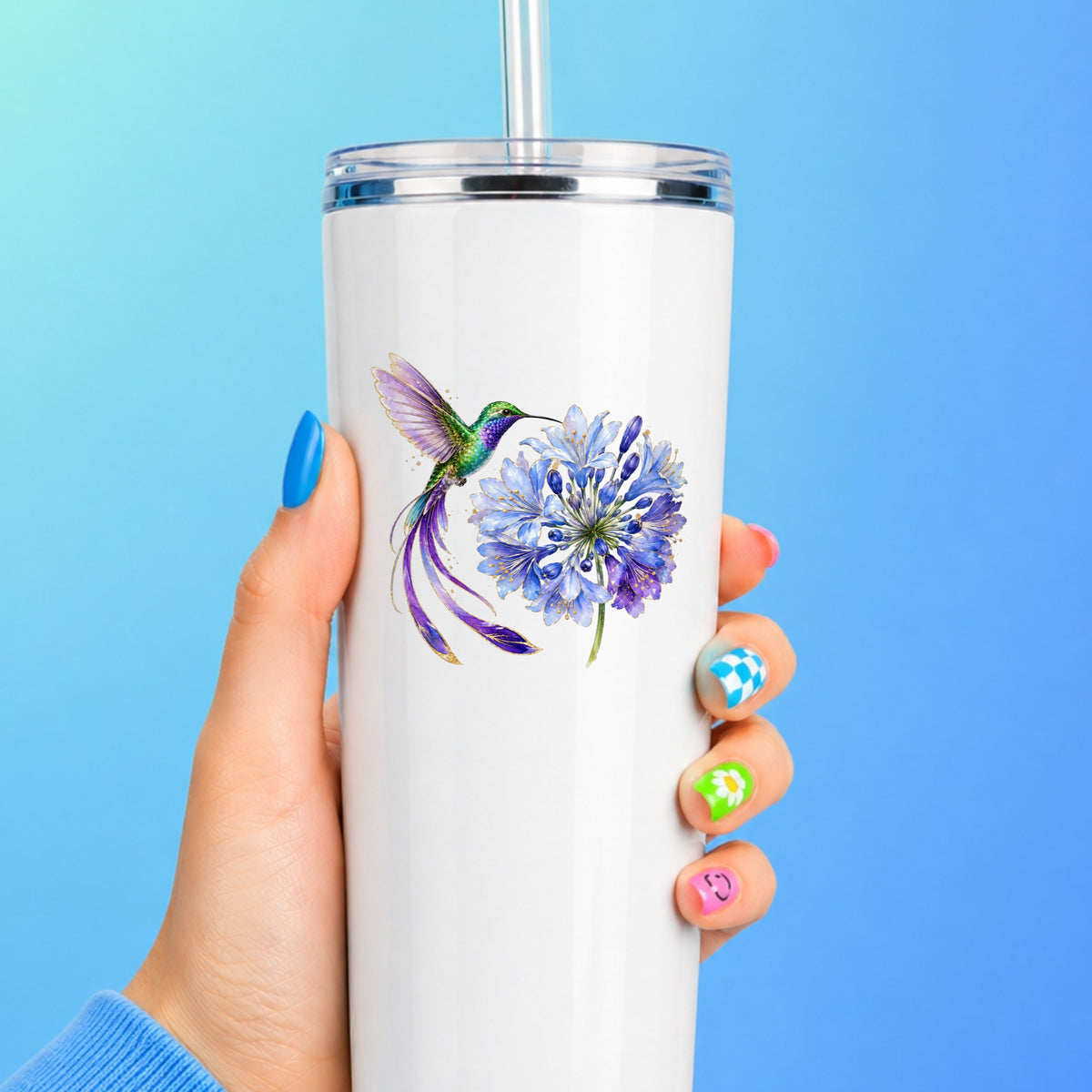Hummingbird Blue Agapanthus UV DTF sticker applied to a white straw tumbler on a blue background