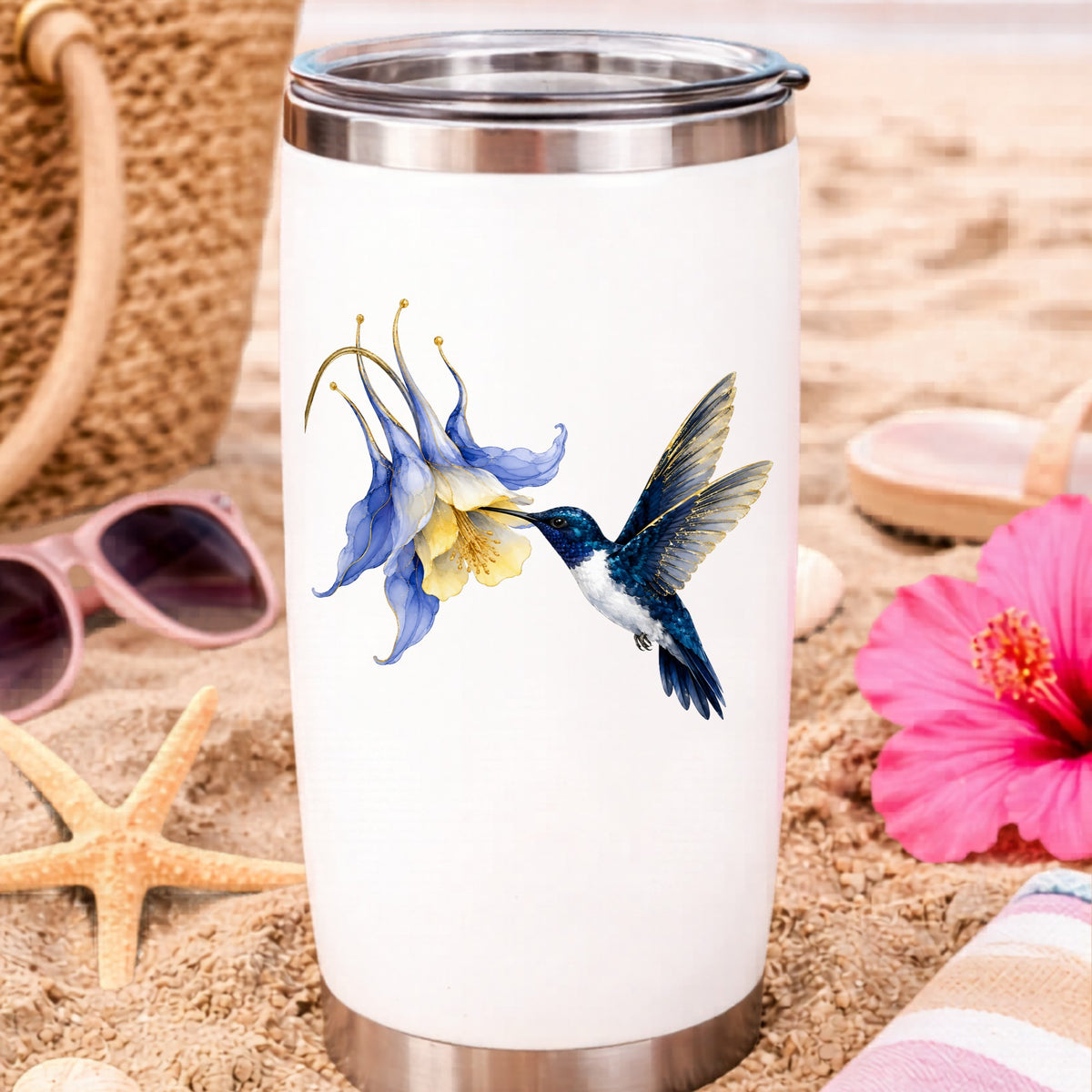 Navy Hummingbird Blue Columbine UV DTF sticker applied to a white travel tumbler on beach sand