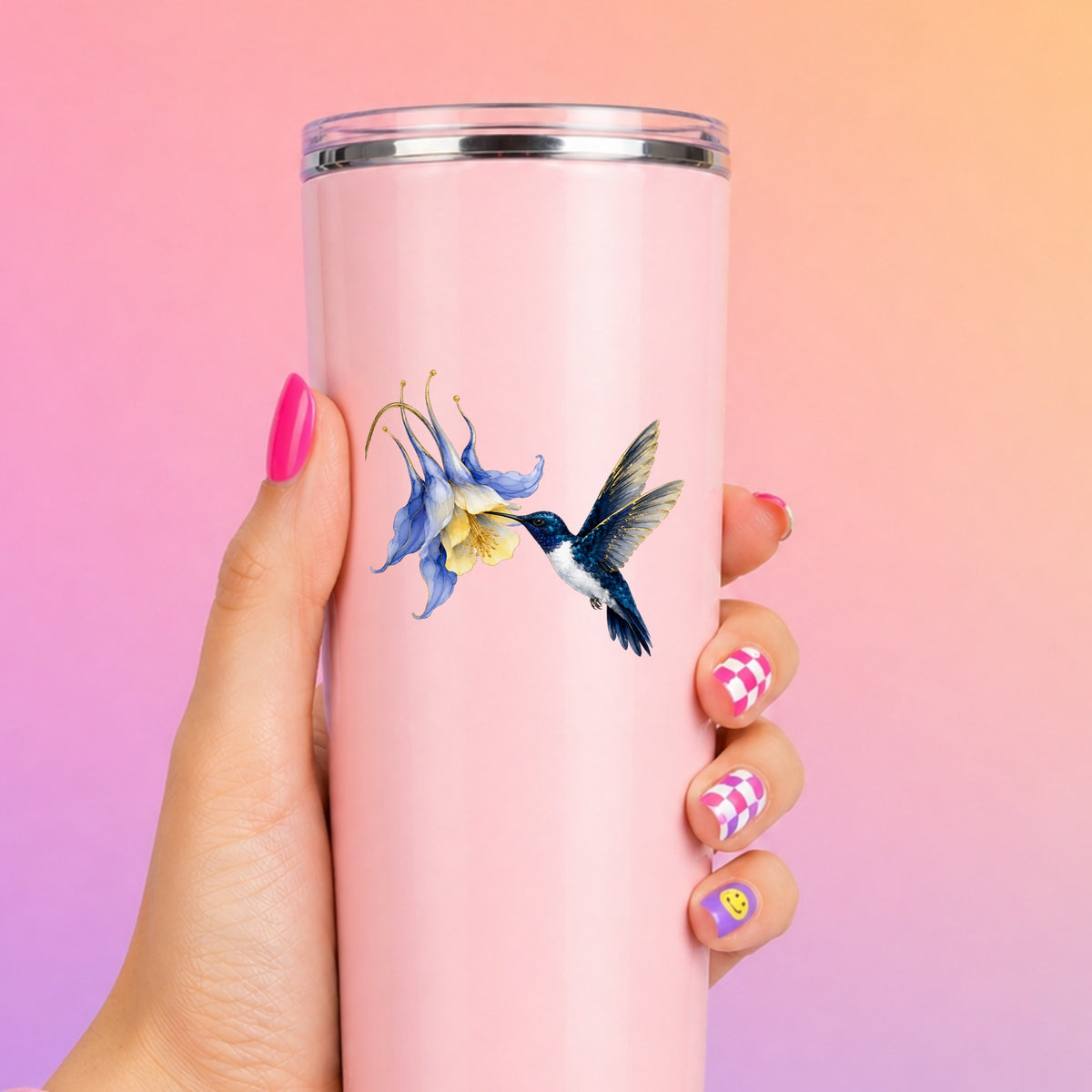 Navy Hummingbird Blue Columbine UV DTF sticker applied to a tall pink tumbler on a pink and orange background