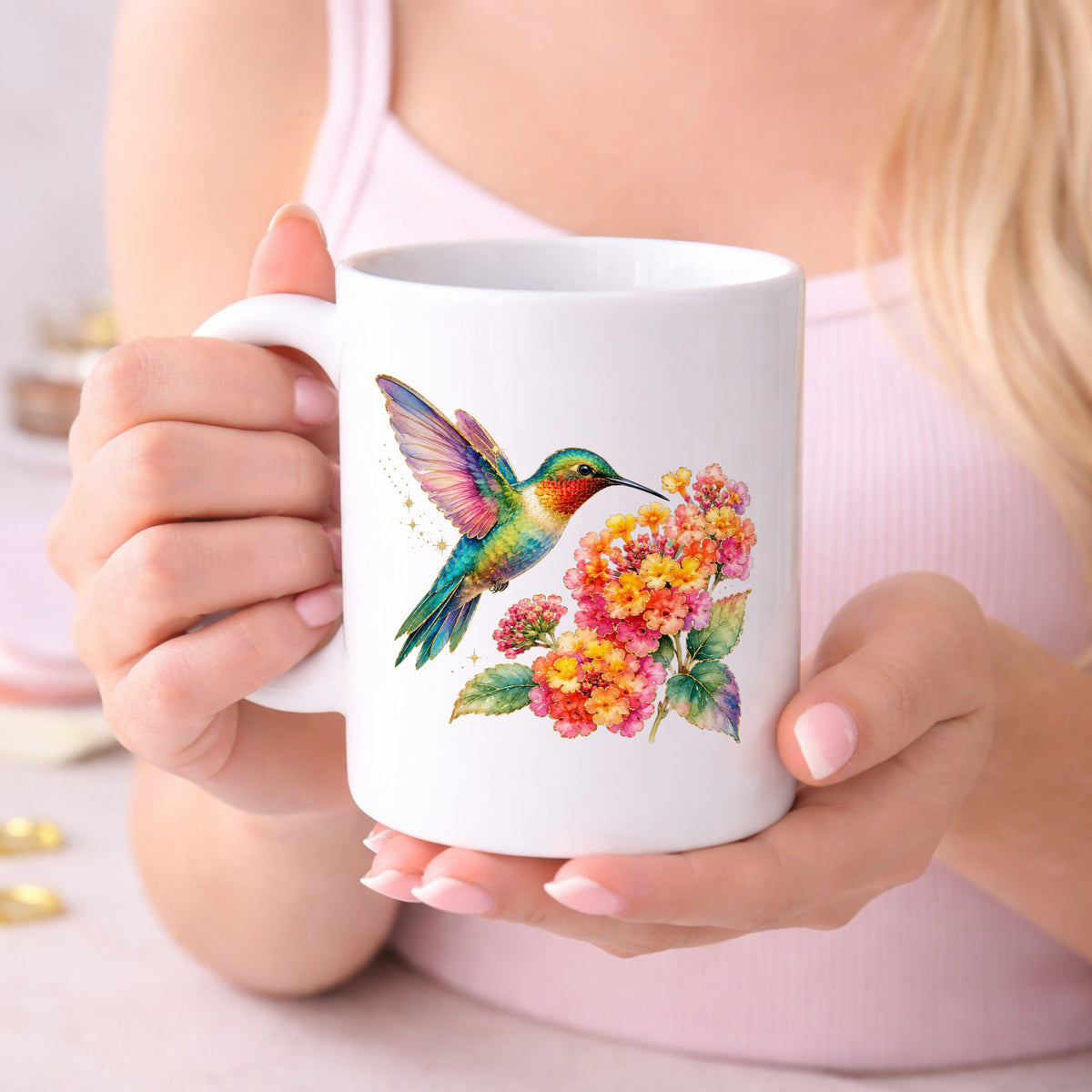 Rainbow Hummingbird Lantana UV DTF sticker applied to a white coffee mug held in both hands
