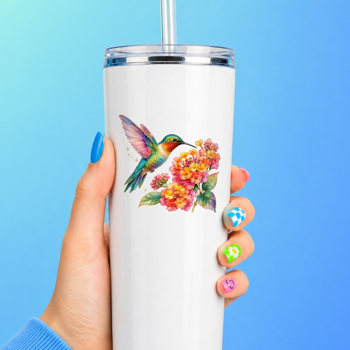 Rainbow Hummingbird Lantana UV DTF sticker applied to a white straw tumbler on a blue background