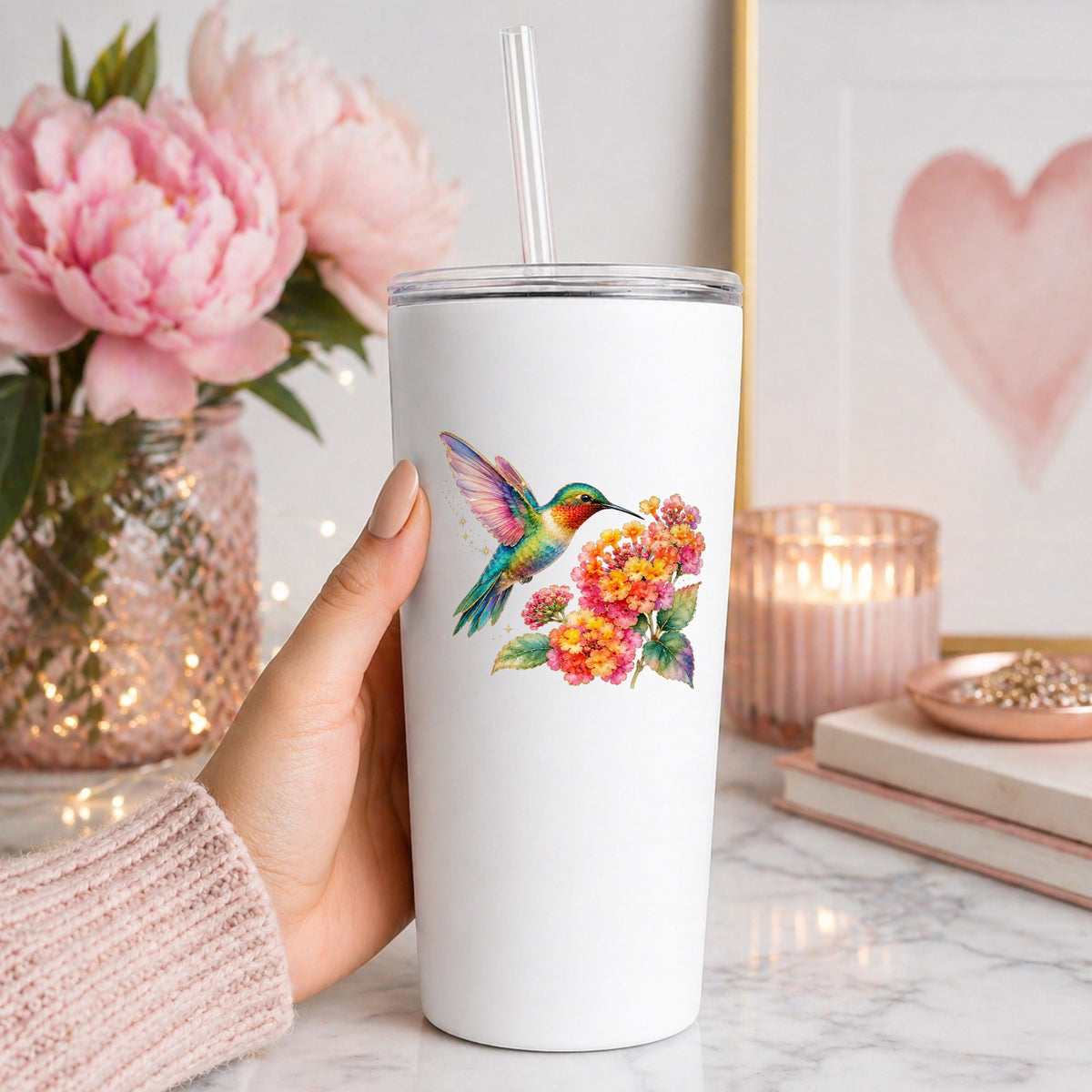 Rainbow Hummingbird Lantana UV DTF sticker applied to a white straw tumbler beside pink peonies