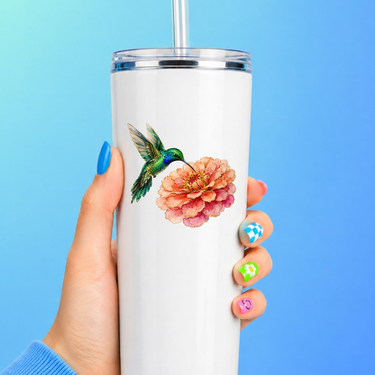 Hummingbird Coral Zinnia UV DTF sticker applied to a white straw tumbler on a blue background