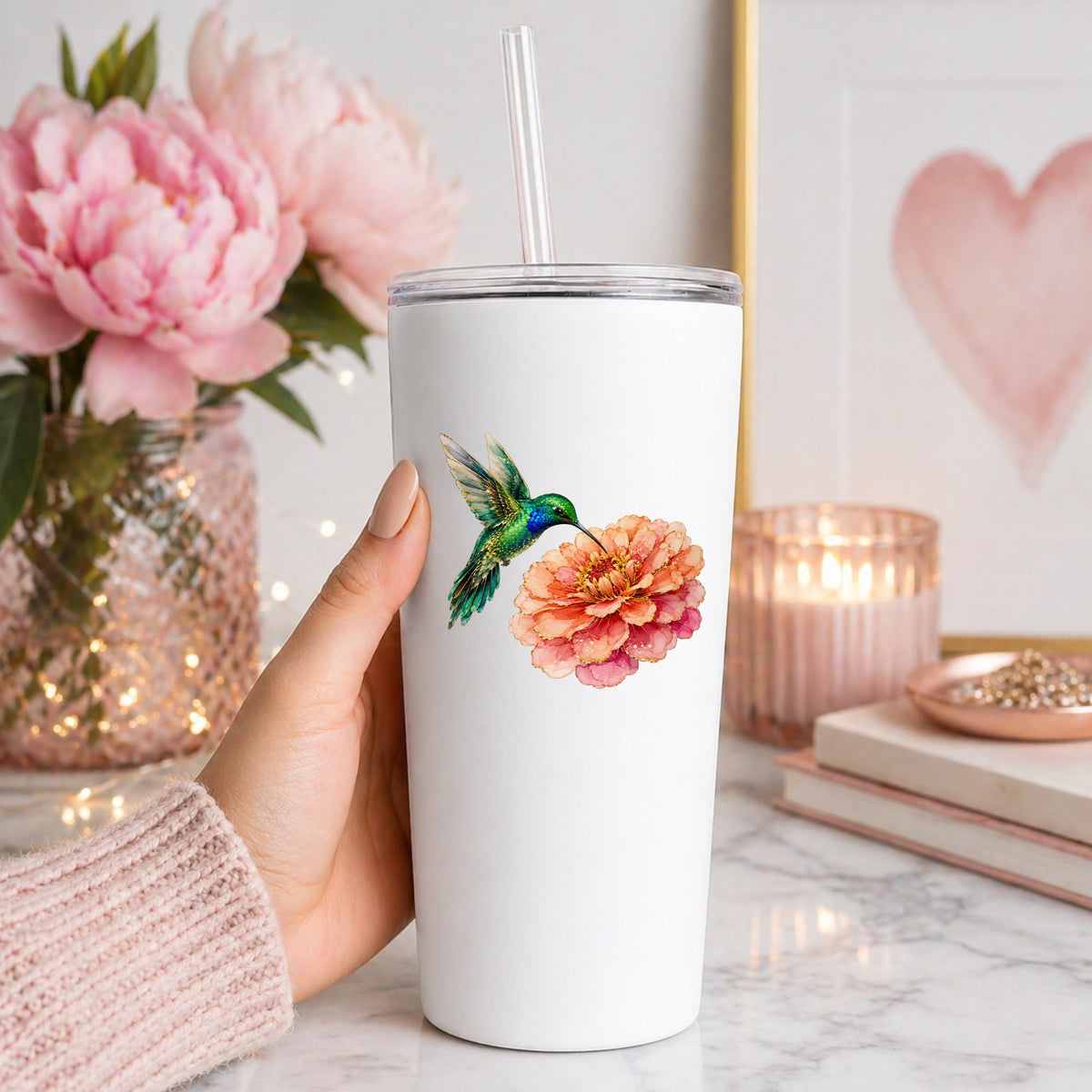 Hummingbird Coral Zinnia UV DTF sticker applied to a white straw tumbler beside pink peonies