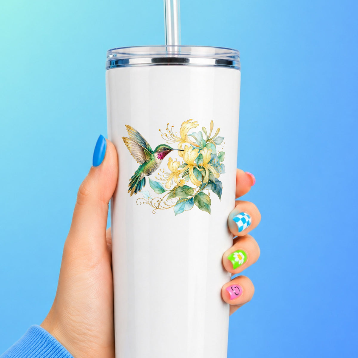 Hummingbird Yellow Honeysuckle UV DTF sticker applied to a white straw tumbler on a blue background