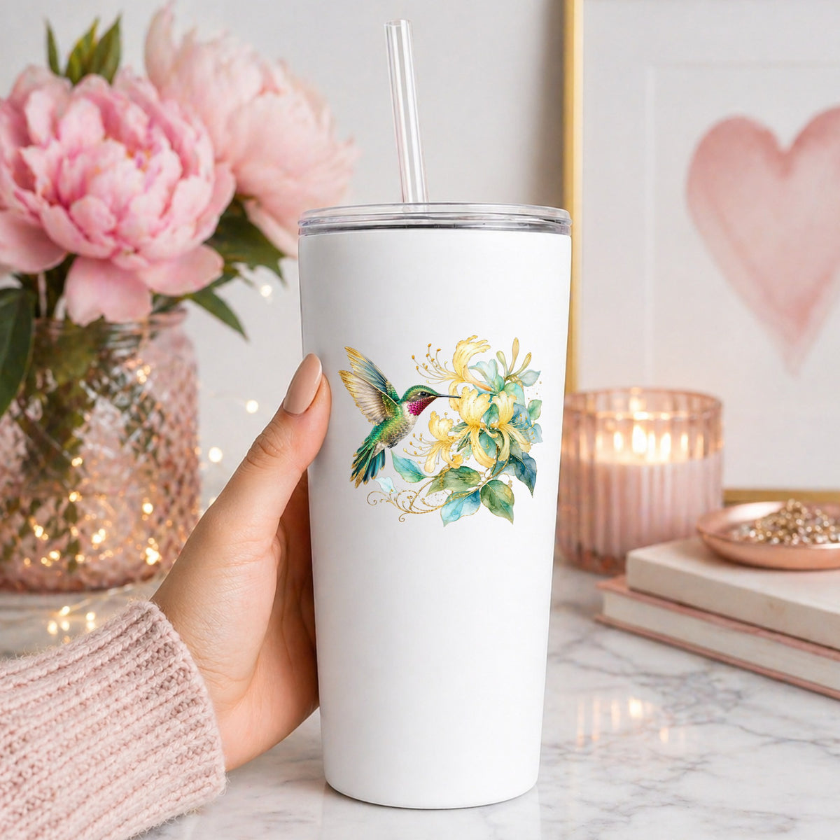 Hummingbird Yellow Honeysuckle UV DTF sticker applied to a white straw tumbler beside pink peonies
