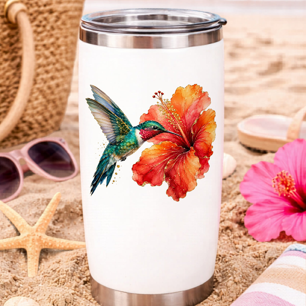 Hummingbird Red Hibiscus UV DTF sticker applied to a white travel tumbler on beach sand
