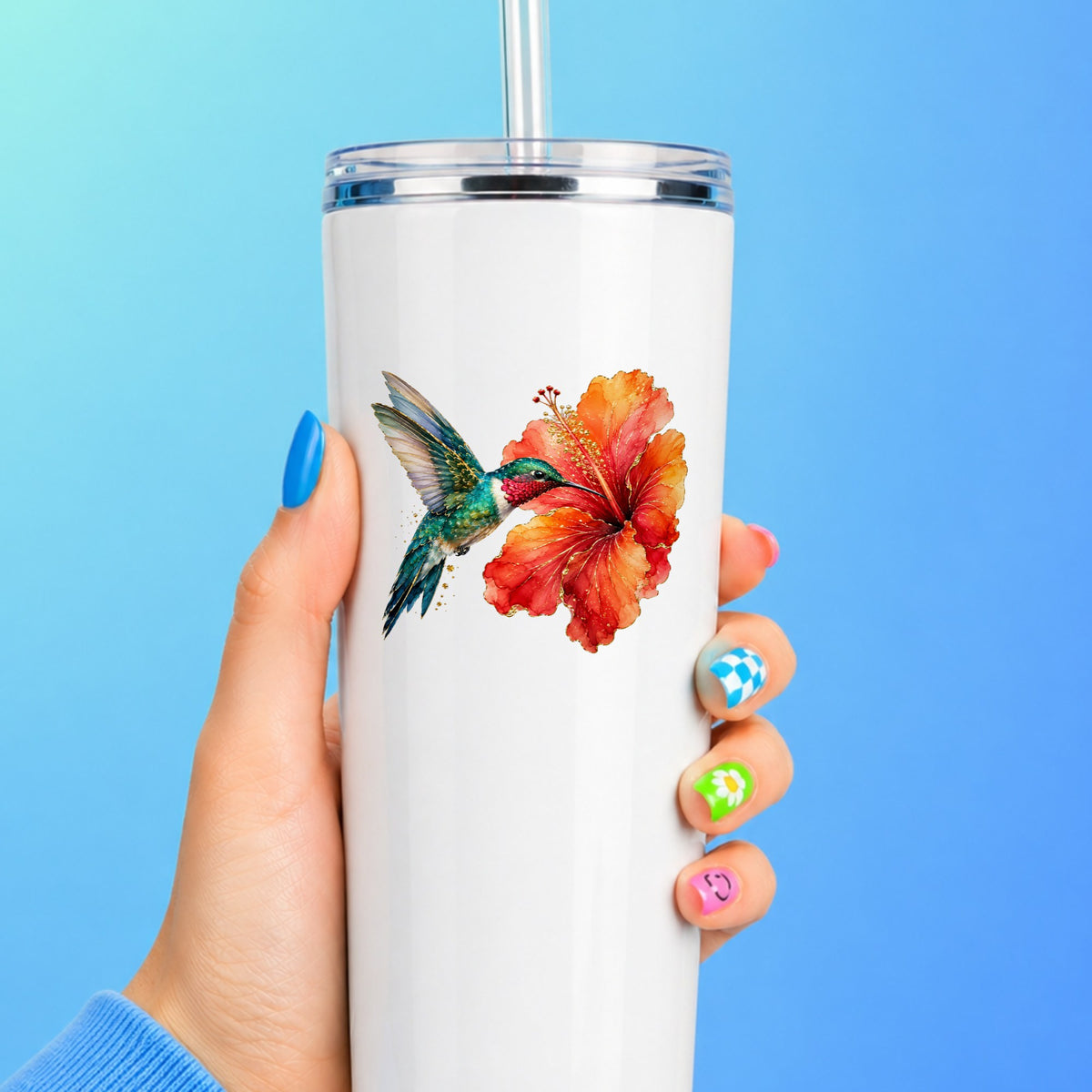 Hummingbird Red Hibiscus UV DTF sticker applied to a white straw tumbler on a blue background