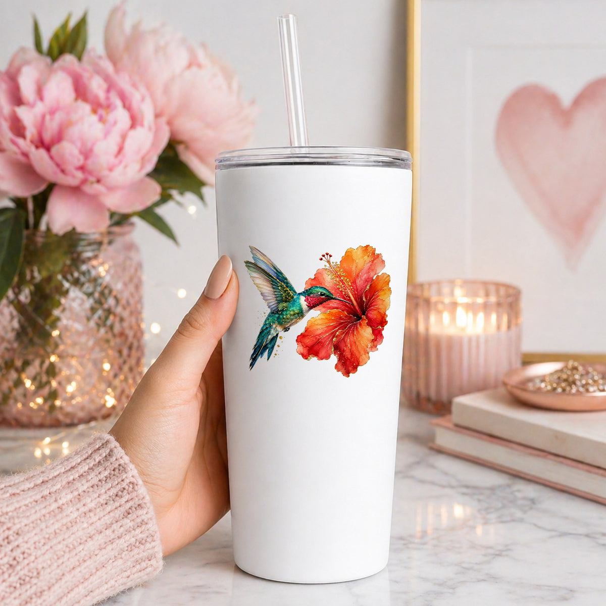 Hummingbird Red Hibiscus UV DTF sticker applied to a white straw tumbler beside pink peonies