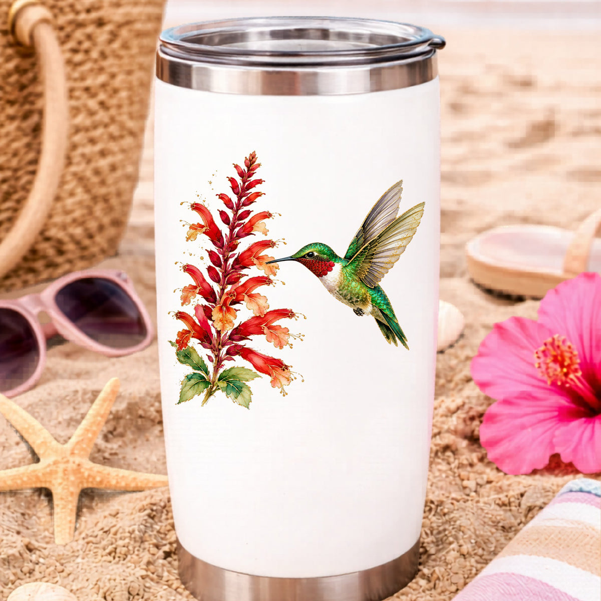 Hummingbird Red Salvia UV DTF sticker applied to a white travel tumbler on beach sand