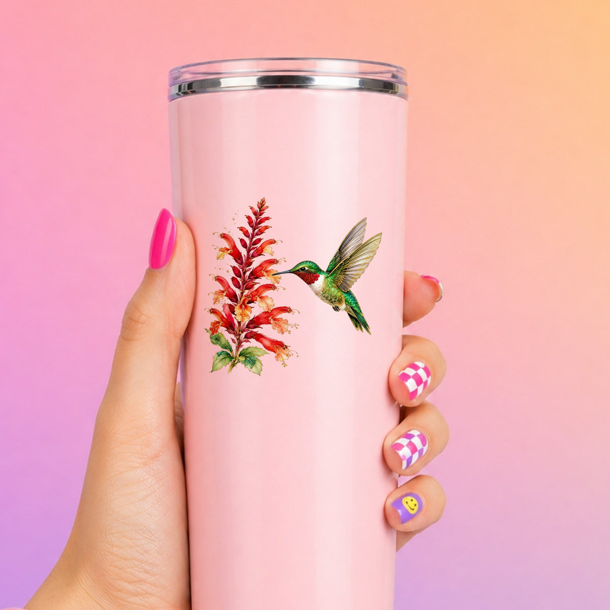 Hummingbird Red Salvia UV DTF sticker applied to a tall pink tumbler on a pink and orange background