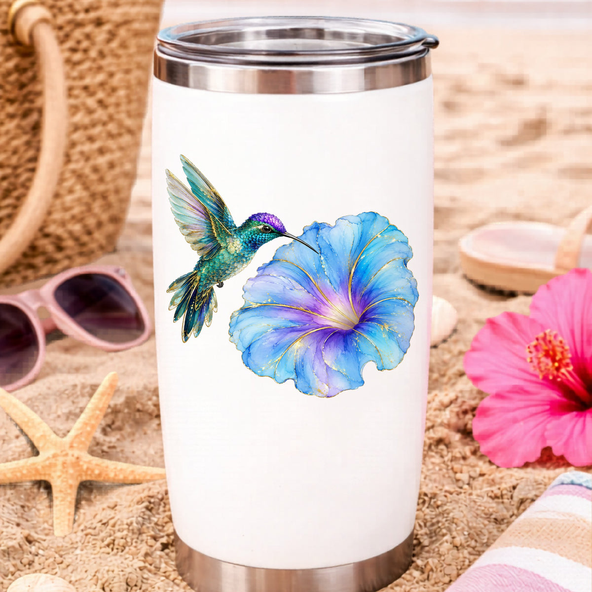 Teal Hummingbird Blue Morning Glory UV DTF sticker applied to a white travel tumbler on beach sand