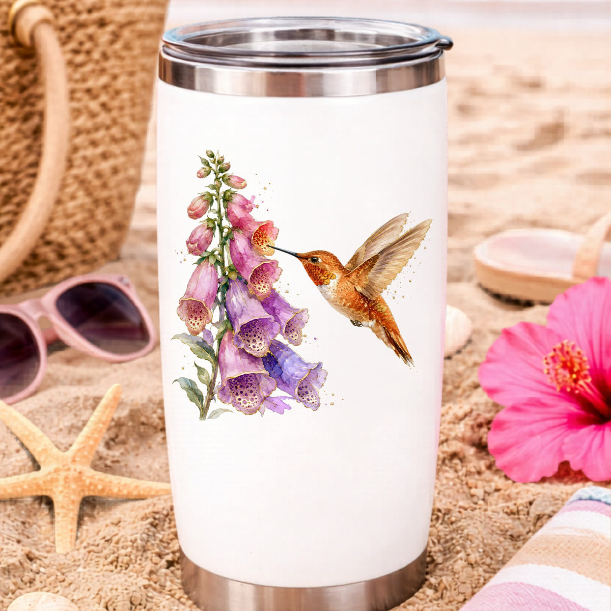 Rufous Hummingbird Pink Foxglove UV DTF sticker applied to a white travel tumbler on beach sand