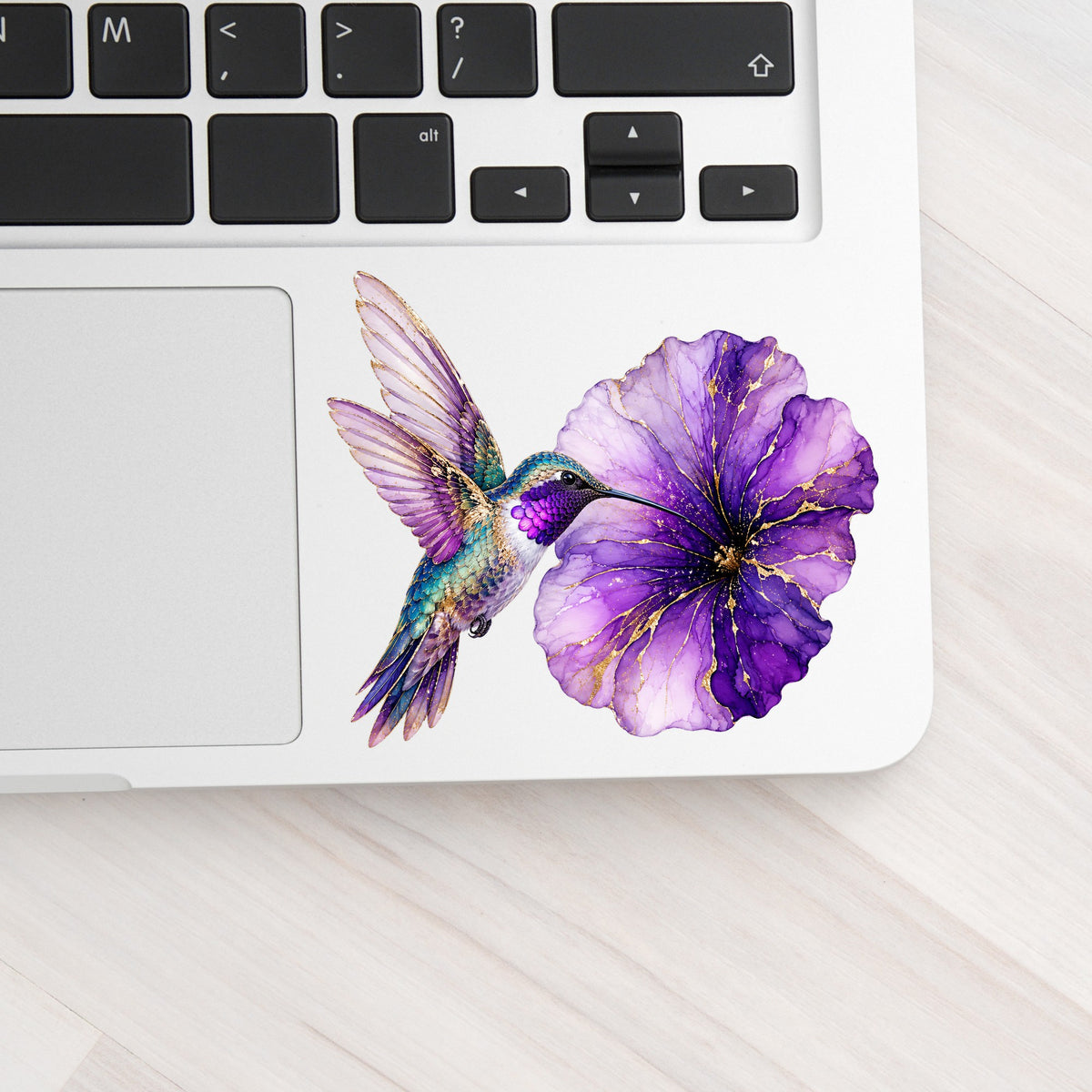 Hummingbird Purple Petunia UV DTF sticker applied to a silver laptop beside the keyboard