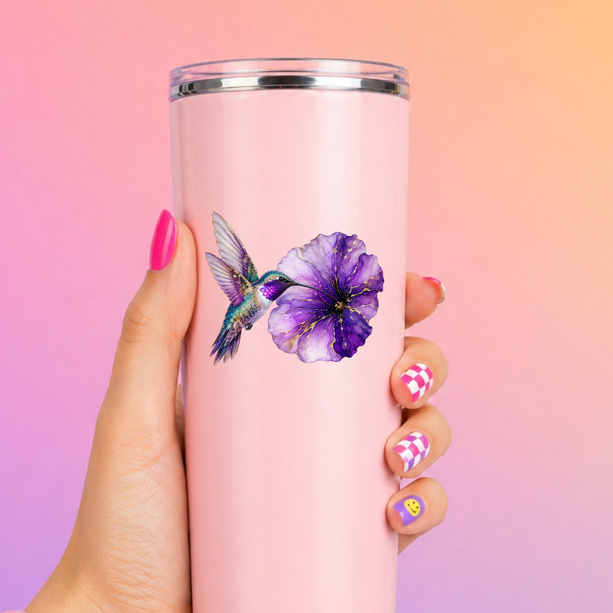Hummingbird Purple Petunia UV DTF sticker applied to a tall pink tumbler on a pink and orange background