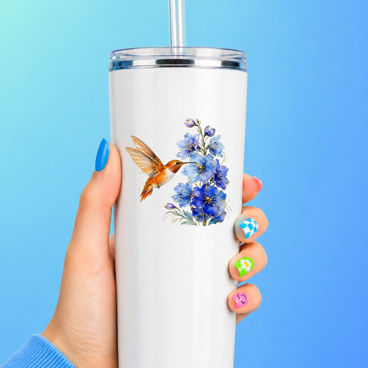 Rufous Hummingbird Blue Delphinium UV DTF sticker applied to a white straw tumbler on a blue background