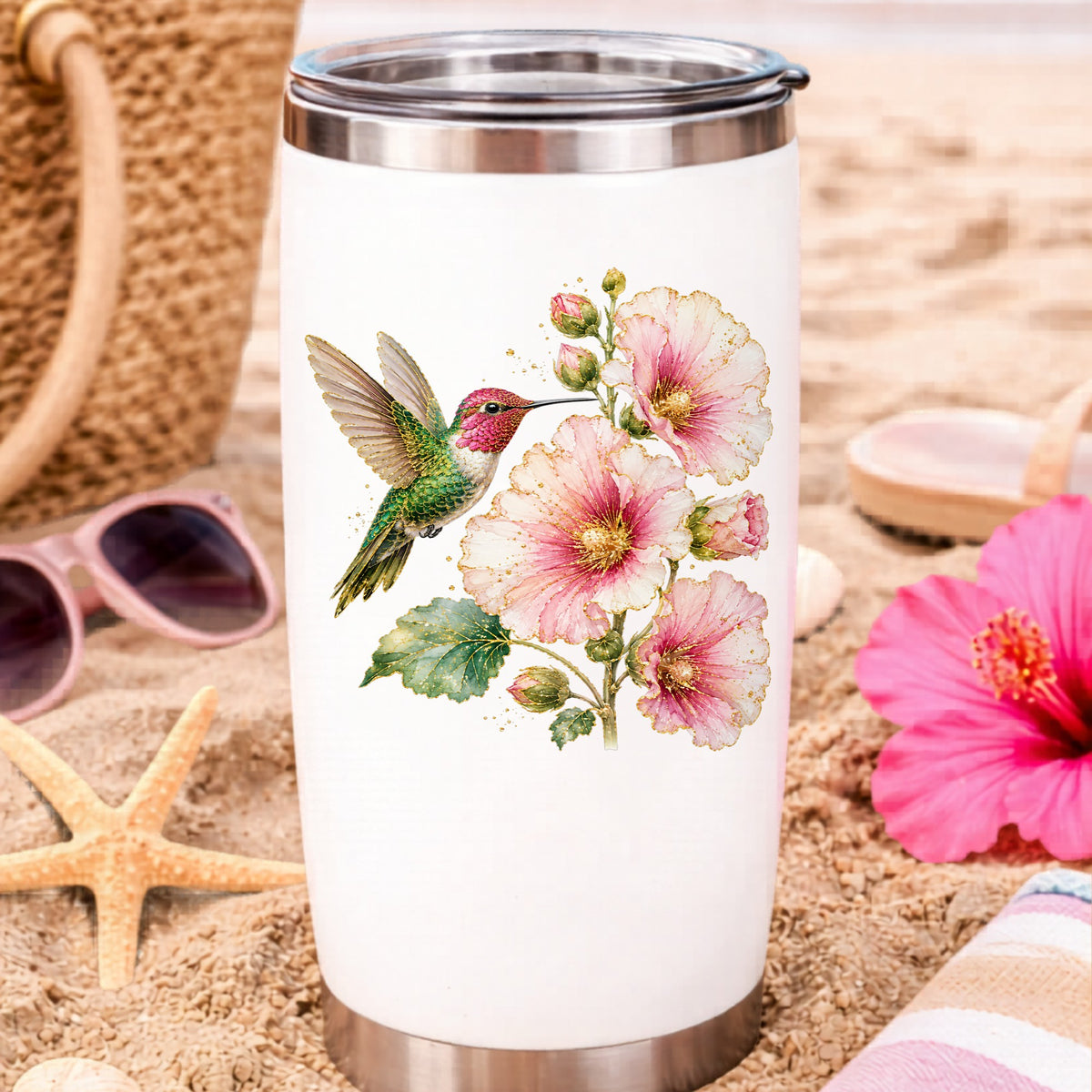 Hummingbird Pink Hollyhock UV DTF sticker applied to a white travel tumbler on beach sand