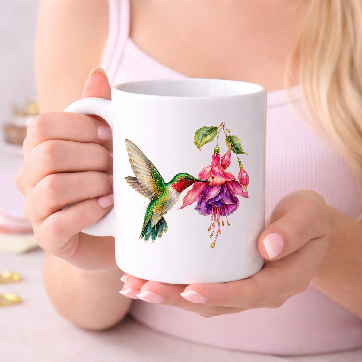 Hummingbird Fuchsia Flower UV DTF sticker applied to a white coffee mug held in both hands