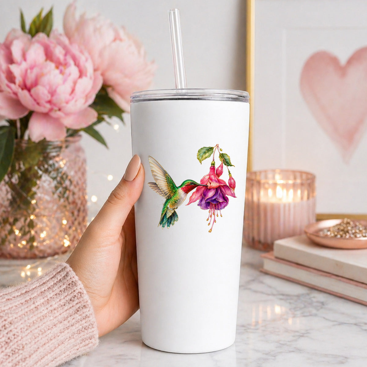 Hummingbird Fuchsia Flower UV DTF sticker applied to a white straw tumbler beside pink peonies