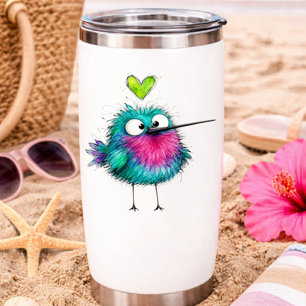 Fluffy Teal Pink Hummingbird UV DTF sticker applied to a white travel tumbler on beach sand