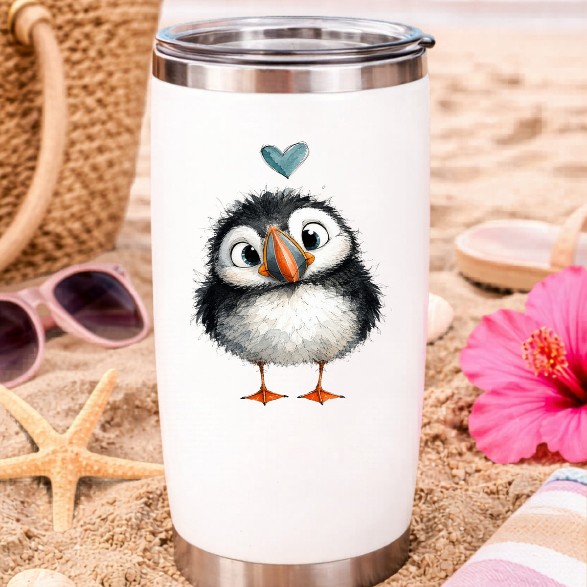 Funny Puffin UV DTF sticker applied to a white travel tumbler on beach sand