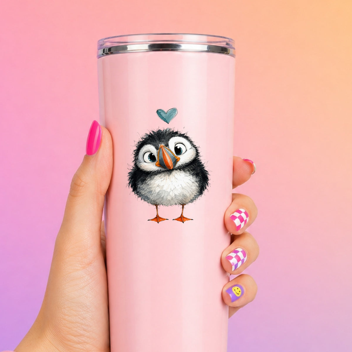 Funny Puffin UV DTF sticker applied to a tall pink tumbler on a pink and orange background