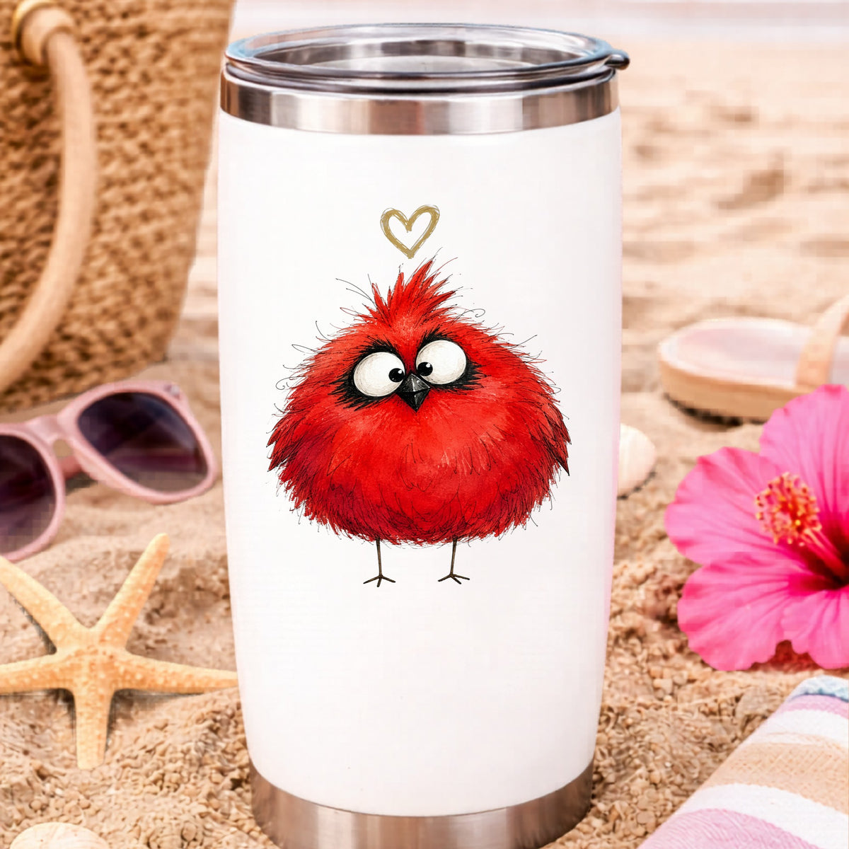 Fluffy Red Cardinal UV DTF sticker applied to a white travel tumbler on beach sand