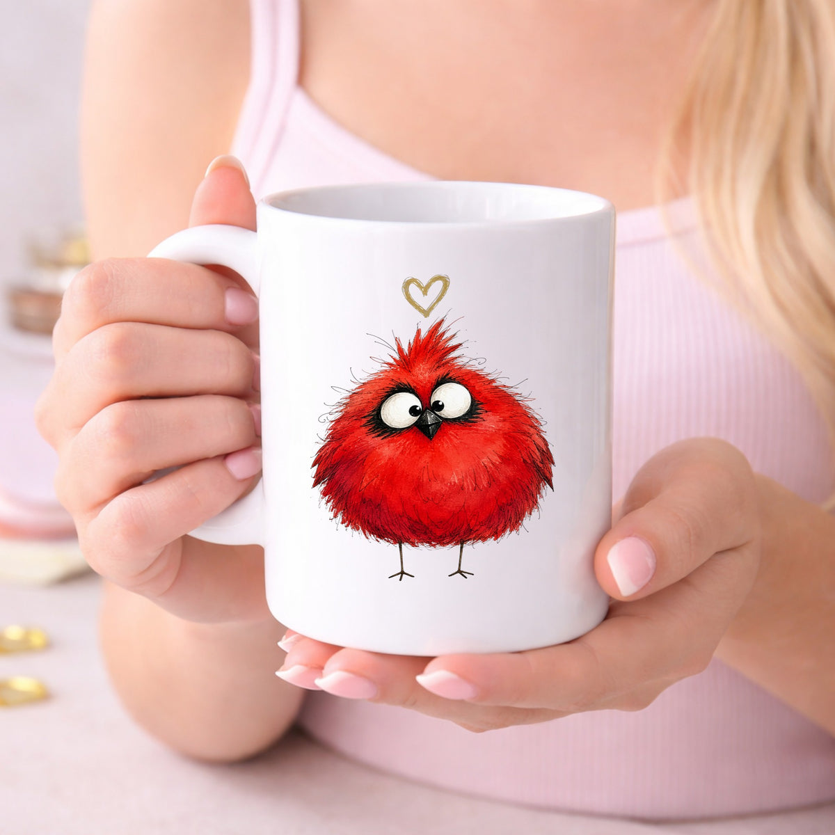 Fluffy Red Cardinal UV DTF sticker applied to a white coffee mug held in both hands