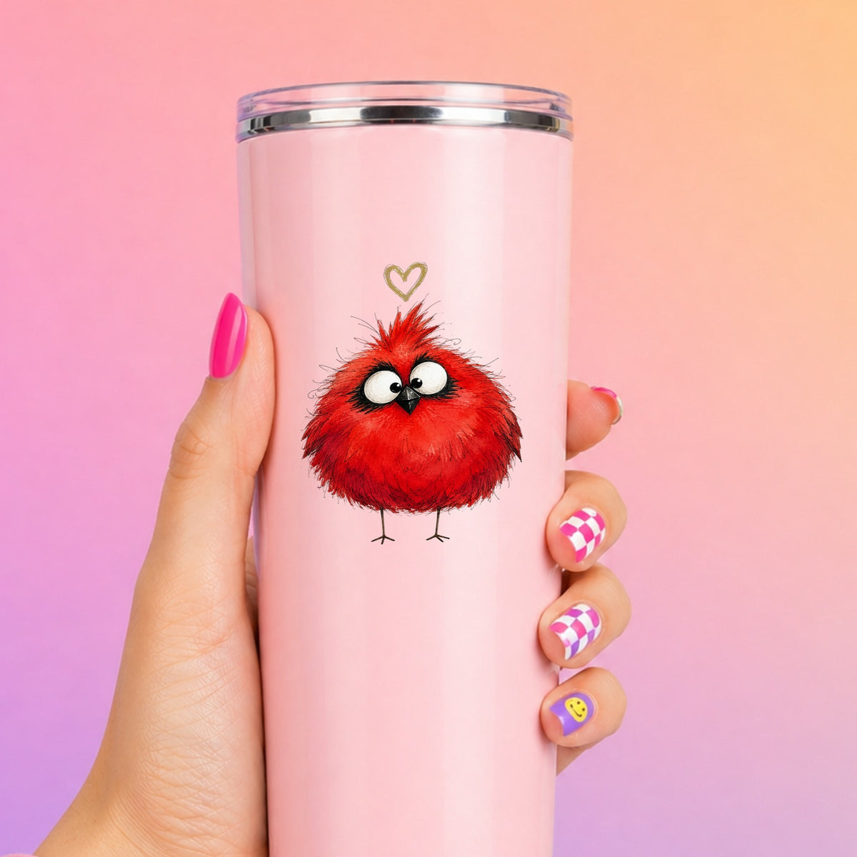 Fluffy Red Cardinal UV DTF sticker applied to a tall pink tumbler on a pink and orange background