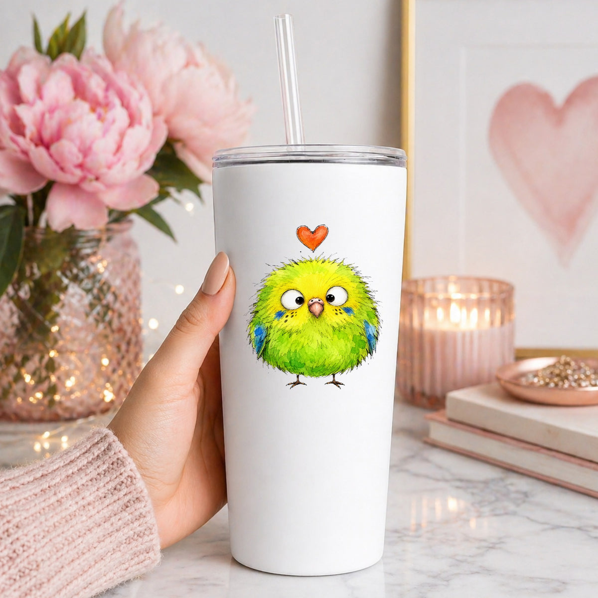 Fluffy Green Parakeet UV DTF sticker applied to a white straw tumbler beside pink peonies