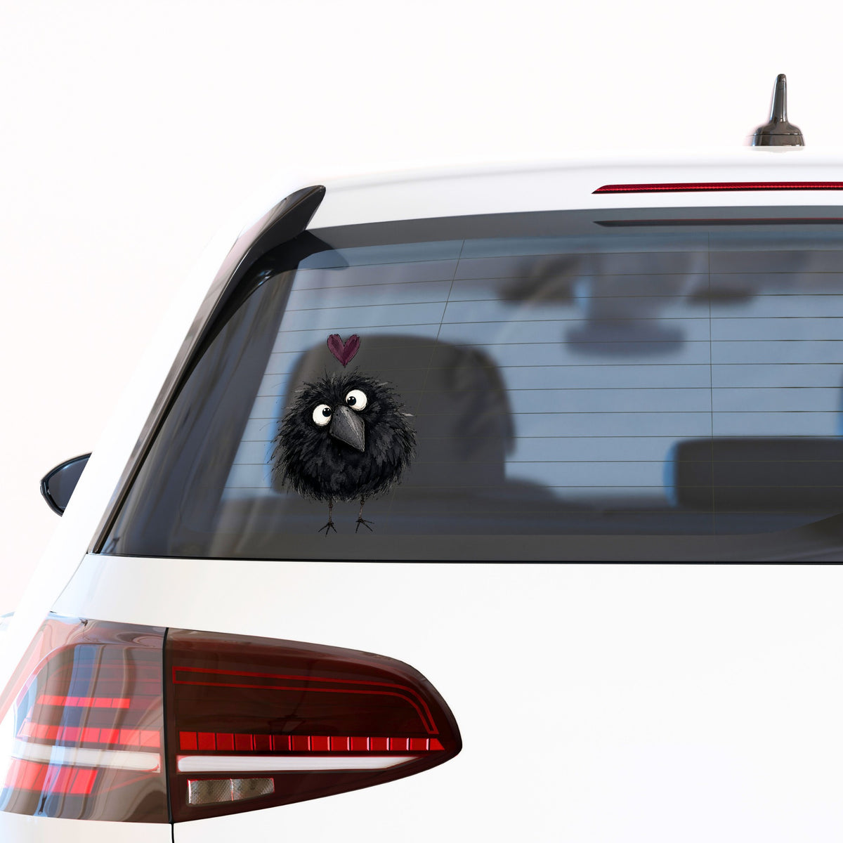 Fluffy Black Crow UV DTF sticker applied to the rear window of a white car