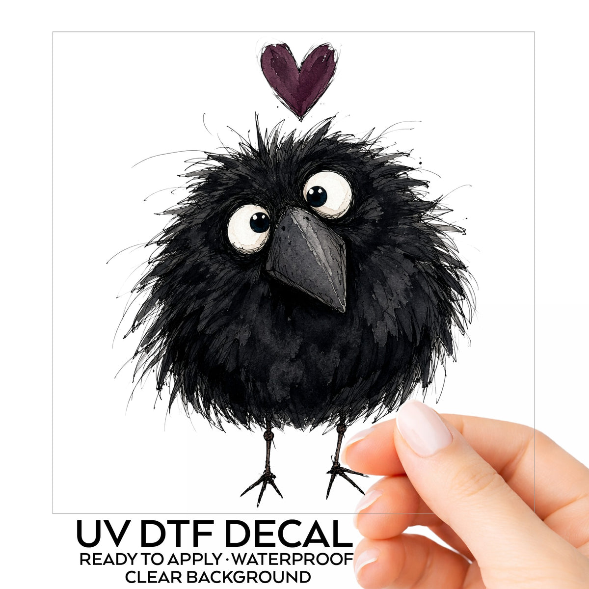 Fluffy Black Crow UV DTF sticker on its backing card, held in hand