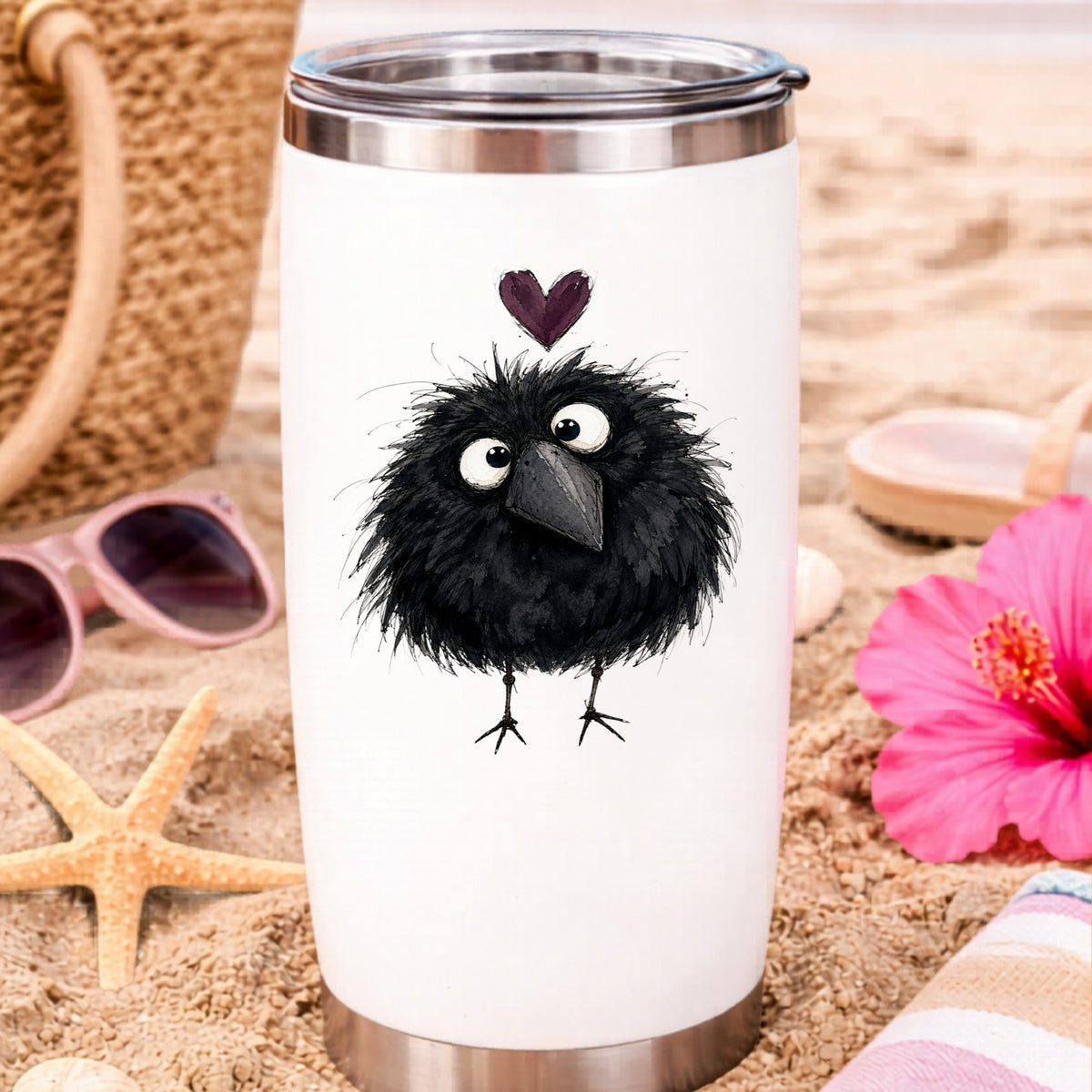Fluffy Black Crow UV DTF sticker applied to a white travel tumbler on beach sand