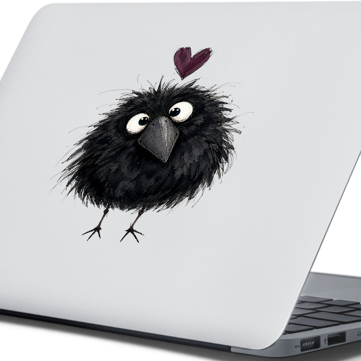 Fluffy Black Crow UV DTF sticker applied to the lid of a silver laptop