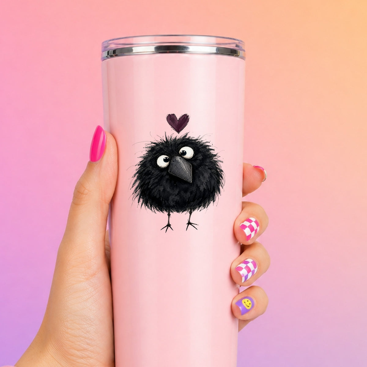 Fluffy Black Crow UV DTF sticker applied to a tall pink tumbler on a pink and orange background