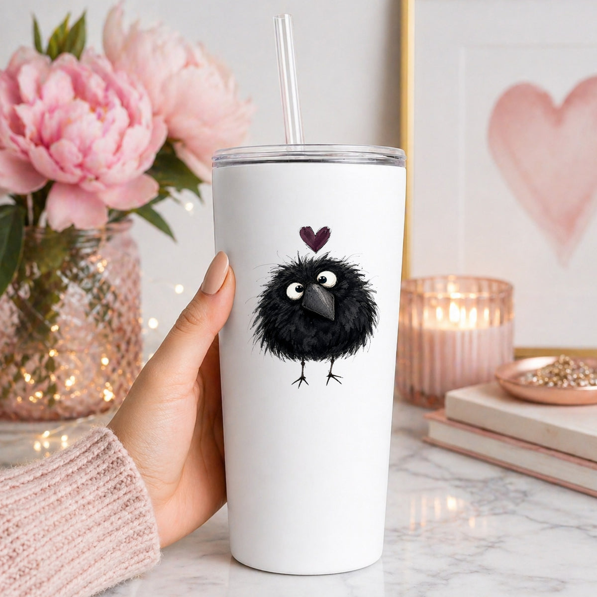 Fluffy Black Crow UV DTF sticker applied to a white straw tumbler beside pink peonies