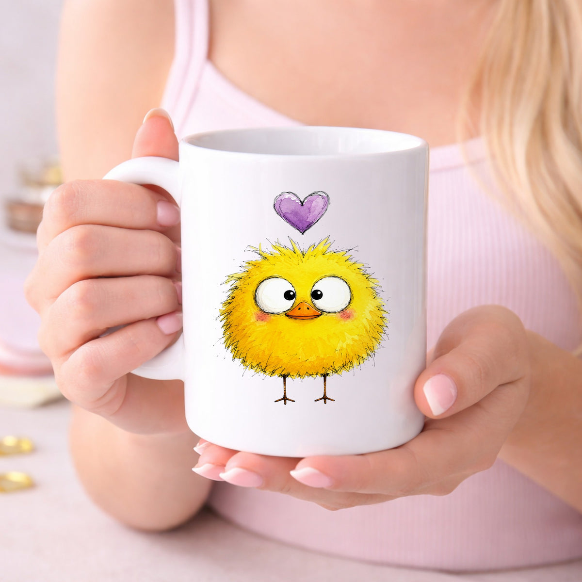 Fluffy Yellow Duckling UV DTF sticker applied to a white coffee mug held in both hands