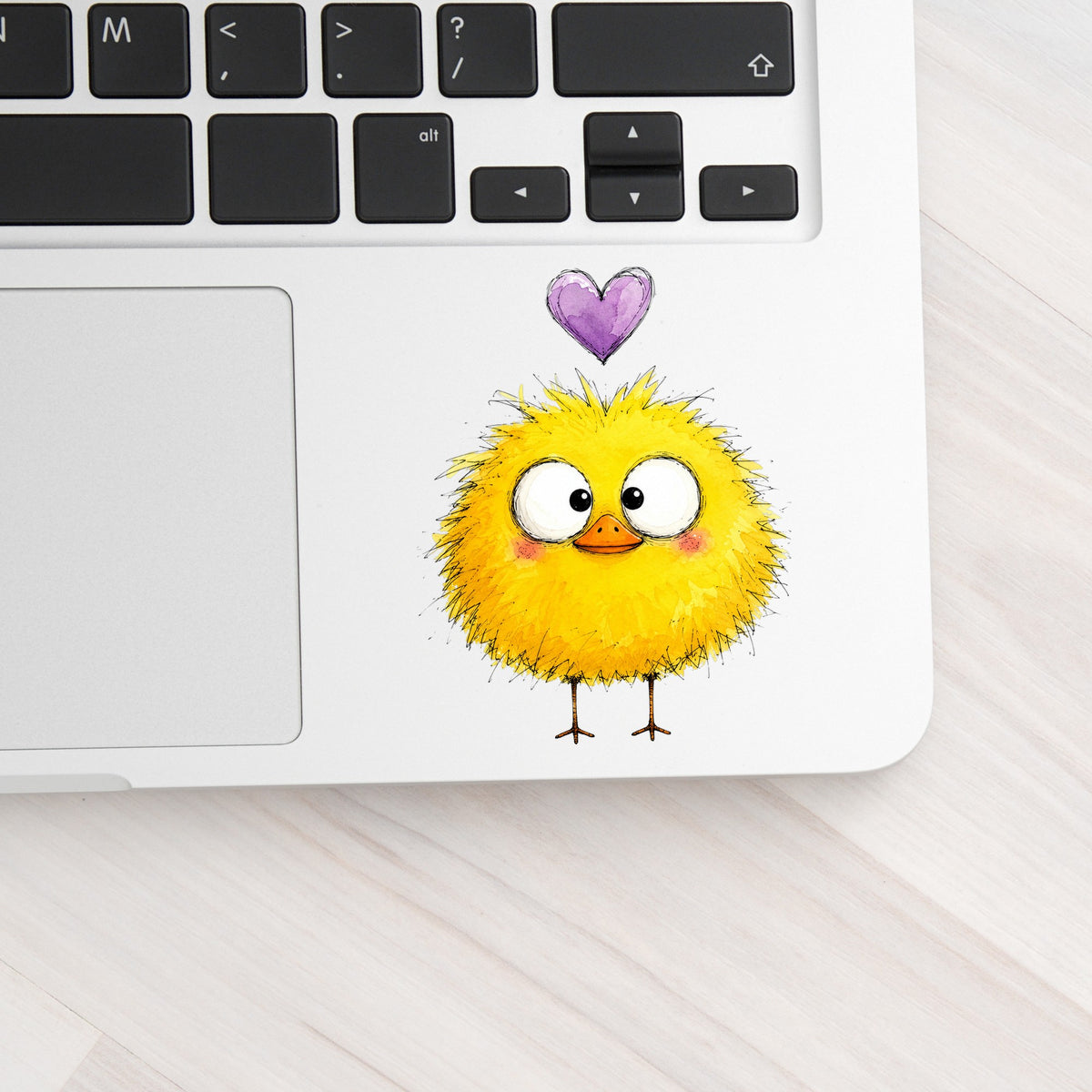 Fluffy Yellow Duckling UV DTF sticker applied to a silver laptop beside the keyboard