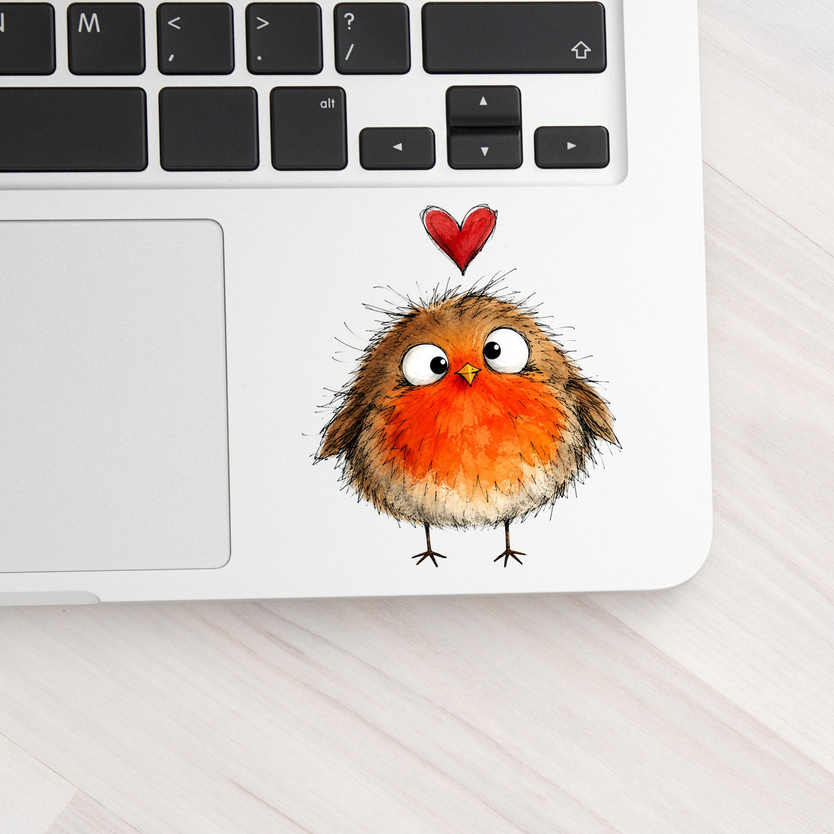 Fluffy Robin UV DTF sticker applied to a silver laptop beside the keyboard