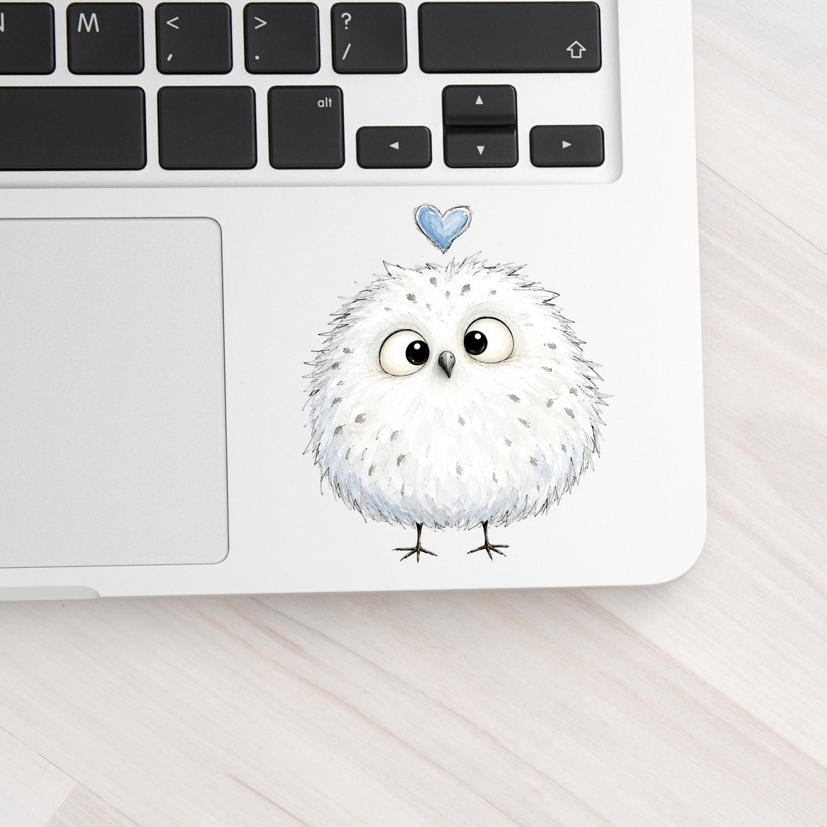 Fluffy White Owl UV DTF sticker applied to a silver laptop beside the keyboard
