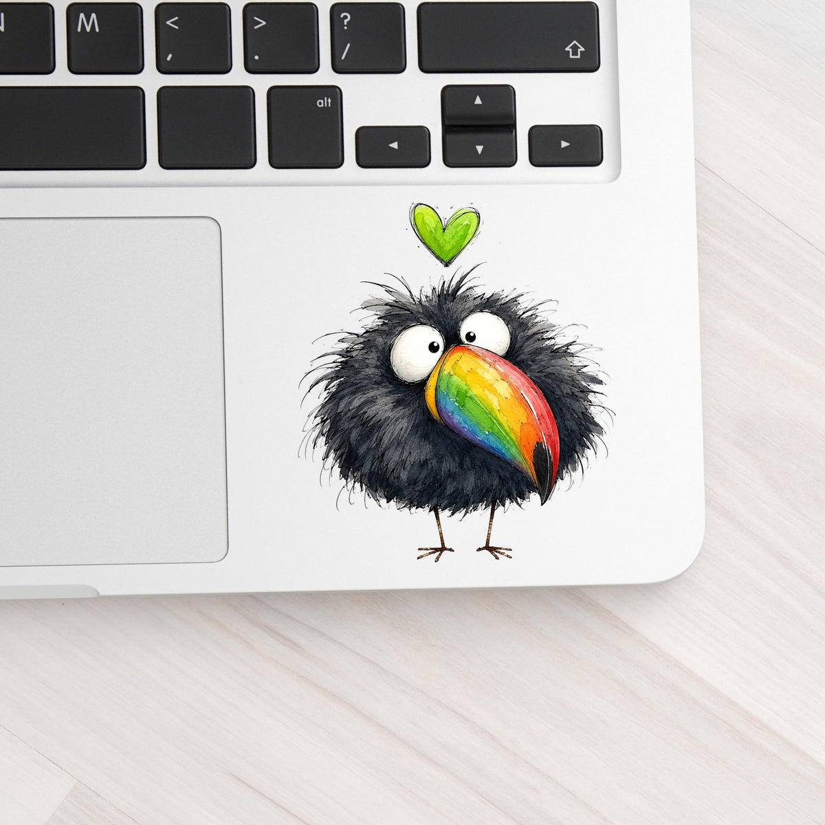 Funny Toucan Rainbow Beak UV DTF sticker applied to a silver laptop beside the keyboard